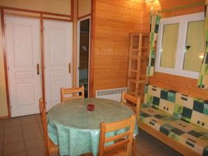 een eetkamer met een tafel en stoelen in een hut bij Chalet Campanules 36 in Mélisey