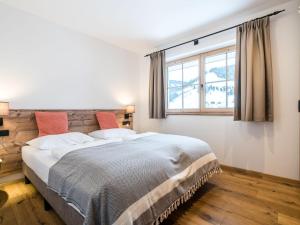 a bedroom with a large bed and a window at Chalet in Muehlbach am Hochkoenig with sauna in Mühlbach am Hochkönig