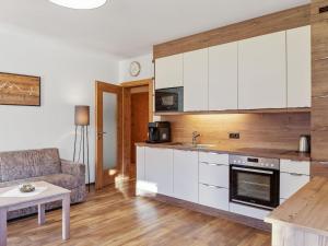 kuchnia z białymi szafkami, kanapą i stołem w obiekcie Chalet in Wald near Ski Slopes w mieście Wald im Pinzgau