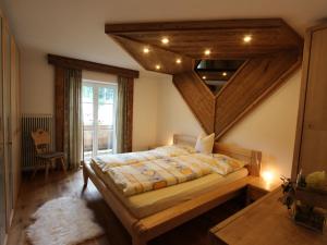 キルヒドルフ・イン・チロルにあるModern Apartment in Kirchdorf with Swimming Poolの木製の天井のベッドルーム1室(大型ベッド1台付)