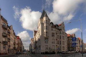 a tall white building with a tower on a street at Wyspa 12 in Poznań