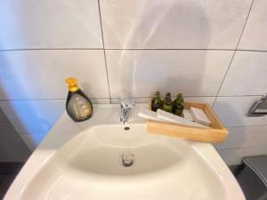 a white sink with a soap dispenser on top of it at Skopelos House Nikols in Loutraki