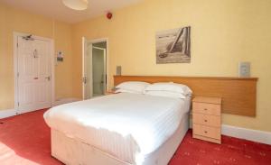 a bedroom with a large bed with white sheets at Lauriston Hotel in Weston-super-Mare