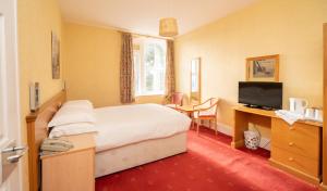 a hotel room with a bed and a television at Lauriston Hotel in Weston-super-Mare