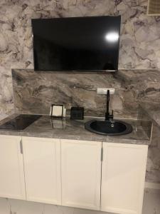 a bathroom with a sink and a tv on a counter at Marton LIDER Krasnodar in Krasnodar
