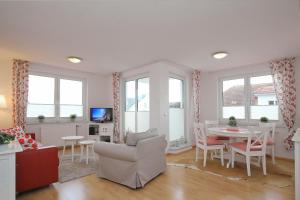 ein Wohnzimmer mit einer Couch und einem Tisch und Stühlen in der Unterkunft Waterkant Wohnung 19 - Klabautermann in Boltenhagen