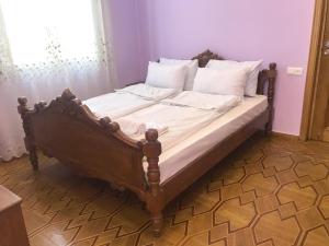 a bed with white sheets and pillows in a bedroom at Wooden Museum in Kutaisi