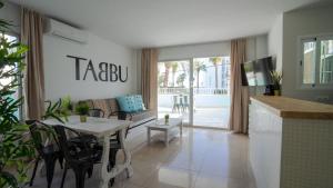 a living room with a table and a couch at Tabbu ibiza apartments in Playa d'en Bossa