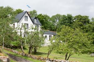 a white house with a flag on top of it at The Albannach in Lochinver