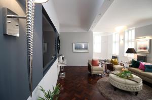 uma sala de estar com um sofá e uma mesa em The Clyne at Utopia Penthouse by MGroupSA em Swansea