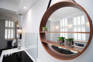 a round mirror on a wall in a room with chairs at The Clyne at Utopia Penthouse by MGroupSA in Swansea