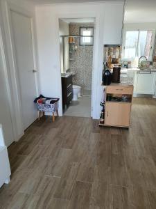 a living room with a wooden floor and a kitchen at Residencial T2 no Parque Verde in Quinta do Conde