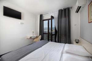 um quarto com uma grande cama branca e uma janela em Meliores Rooms em Šilo