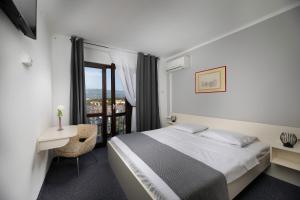 a hotel room with a bed and a window at Meliores Rooms in Šilo