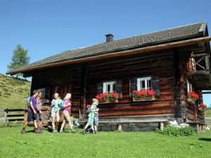 フラッハウにあるApartment near Flachau with mountain viewの丸太小屋の前を歩く集団