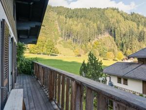 a wooden balcony with a view of a green field at Stylish holiday apartment in Leogang Salzburgerland with terrace in Leogang