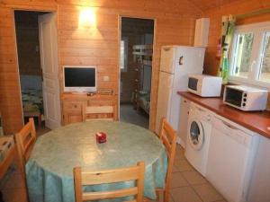 una piccola cucina con tavolo e frigorifero di Chalet Campanules 37 a Mélisey