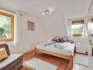 Un dormitorio con una cama con paredes blancas y una ventana en Apartment near the Koralpe ski area 