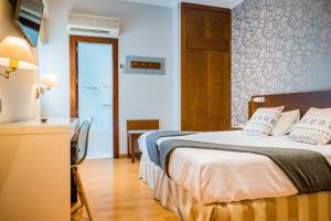 Habitación de hotel con cama y escritorio con mesa en Hotel Costasol, en Almería