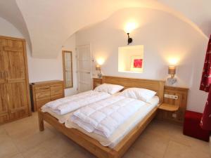 a bedroom with a large bed with white sheets at Traditional Holiday Home with Sauna in Niedernsill in Niedernsill