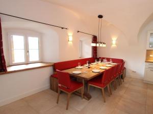 a dining room with a table and red chairs at Traditional Holiday Home with Sauna in Niedernsill in Niedernsill