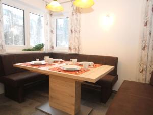 a wooden table with cups and plates on it at Nice Apartment in Kirchberg in Tyrol with Mountain View in Kirchberg in Tirol