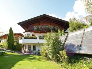 a house with a balcony with plants on it at Animal friendly apartment in Leogang in Leogang