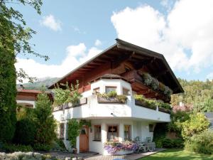 a house with a balcony with flowers on it at Animal friendly apartment in Leogang in Leogang