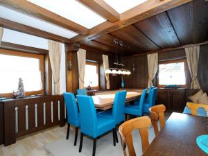 ein Esszimmer mit einem Tisch und blauen Stühlen in der Unterkunft Spacious Chalet near Ski area in Itter in Itter