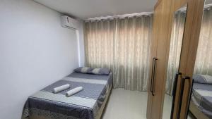 Cette petite chambre comprend 2 lits et une fenêtre. dans l'établissement Sua casa em Foz do Iguaçu. Apt encantador e aconchegante na Vila A., à Foz do Iguaçu