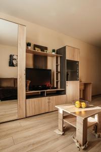 a living room with a table and a tv at Апартаменты в 10мин от м4 in Voronezh