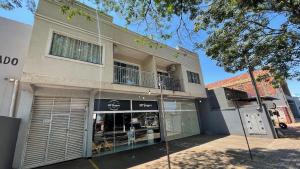 una tienda frente a un edificio con balcón en Sua casa em Foz do Iguaçu. Apt encantador e aconchegante na Vila A. en Foz de Iguazú