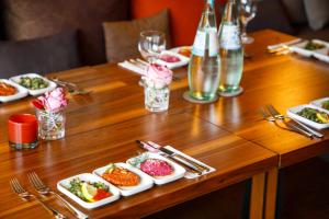 a wooden table with plates of food on it at Boutique Hotel Poppenbütteler Hof in Hamburg