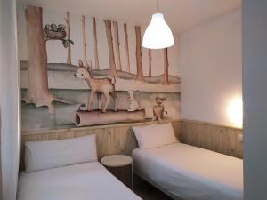 a room with two beds and a mural of a forest at Casa con encanto entre el mar y la montaña, en el corazon de CANTABRIA in Puente Arce