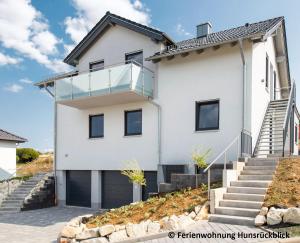 a white house with a glass facade at Ferienwohnung / Haus Hunsrückblick in Hochstetten-Dhaun