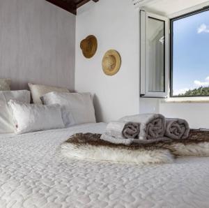 a bedroom with a bed with a blanket and a window at Casa Do Bispo pereiro,Arganil in Coimbra