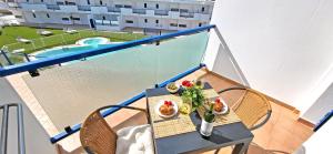 a table with food on a balcony with a pool at Ferienwohnung SOL - Costa Calma - WiFi - Pool - max 4 Personen in Costa Calma