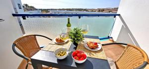 a table with food and glasses of wine on a balcony at Ferienwohnung SOL - Costa Calma - WiFi - Pool - max 4 Personen in Costa Calma