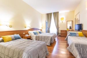 a hotel room with two beds and a tv at Hotel Medici in Rome