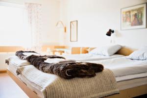 a bedroom with two beds with a faux fur blanket at Köja Fjällhotell in Edsåsdalen