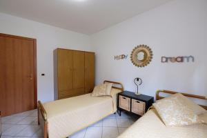 una camera da letto con due letti e uno specchio sul muro di Marina 2 Pineto Vacanza a Pineto