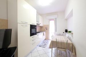 una cucina bianca con un tavolo e delle sedie di Marina 2 Pineto Vacanza a Pineto Altre 8 foto