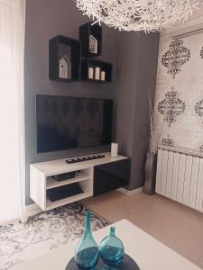 a living room with a tv and two vases on a table at Apartment Gaia in Umag