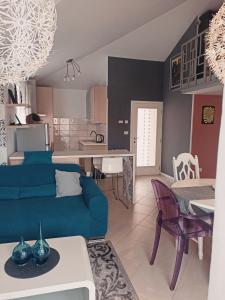 a living room with a blue couch and a kitchen at Apartment Gaia in Umag