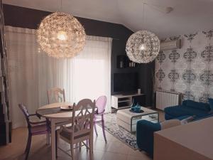 sala de estar con mesa, sillas y lámparas de araña en Apartment Gaia, en Umag