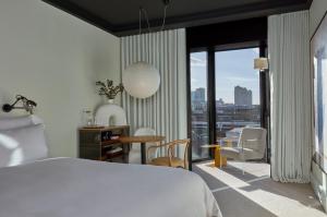 
a hotel room with a large window overlooking the ocean at One Hundred Shoreditch in London
