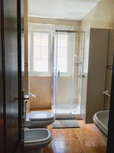 ein Badezimmer mit 2 WCs und einer Dusche in der Unterkunft Apartamento Praia de Quenxe in Corcubión