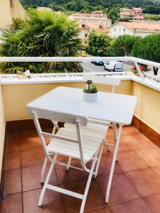 einen weißen Tisch und einen Stuhl auf dem Balkon in der Unterkunft Apartamento Praia de Quenxe in Corcubión