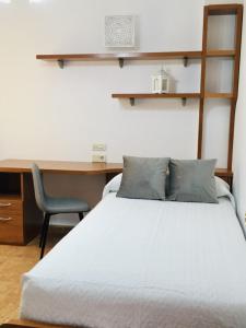 Schlafzimmer mit einem Bett, einem Schreibtisch und einem Stuhl in der Unterkunft Apartamento Praia de Quenxe in Corcubión