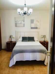 ein Schlafzimmer mit einem großen Bett und zwei Nachttischen in der Unterkunft Apartamento Praia de Quenxe in Corcubión